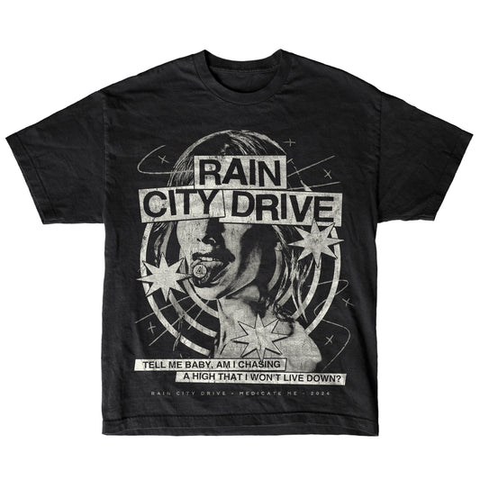 Black T-shirt by Rain City Drive featuring grayscale artwork of a woman's face with stars and orbits. Text: "Rain City Drive" and “Tell me baby, am I chasing a high that I won’t live down? Dedicate Me • 2024.”.